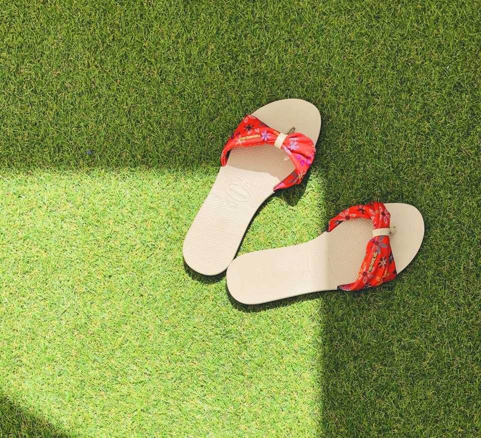 a pair of slippers on a plush and realistic playground turf installed by our team